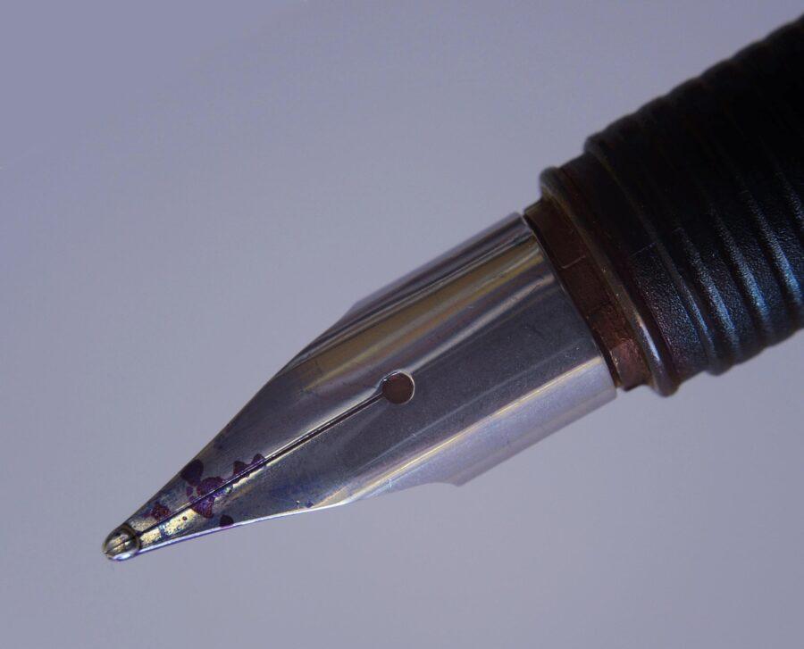 Nahaufnahme einer Füllfederhalter-Spitze aus Metall mit Tinte.