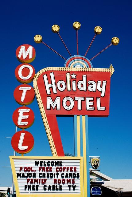 Buntes Schild des Holiday Motels mit verschiedenen Annehmlichkeiten aufgelistet.