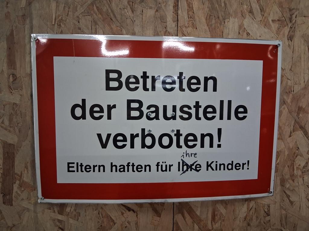 Ein Schild, das den Zutritt zur Baustelle verbietet und auf die Haftung der Eltern hinweist.